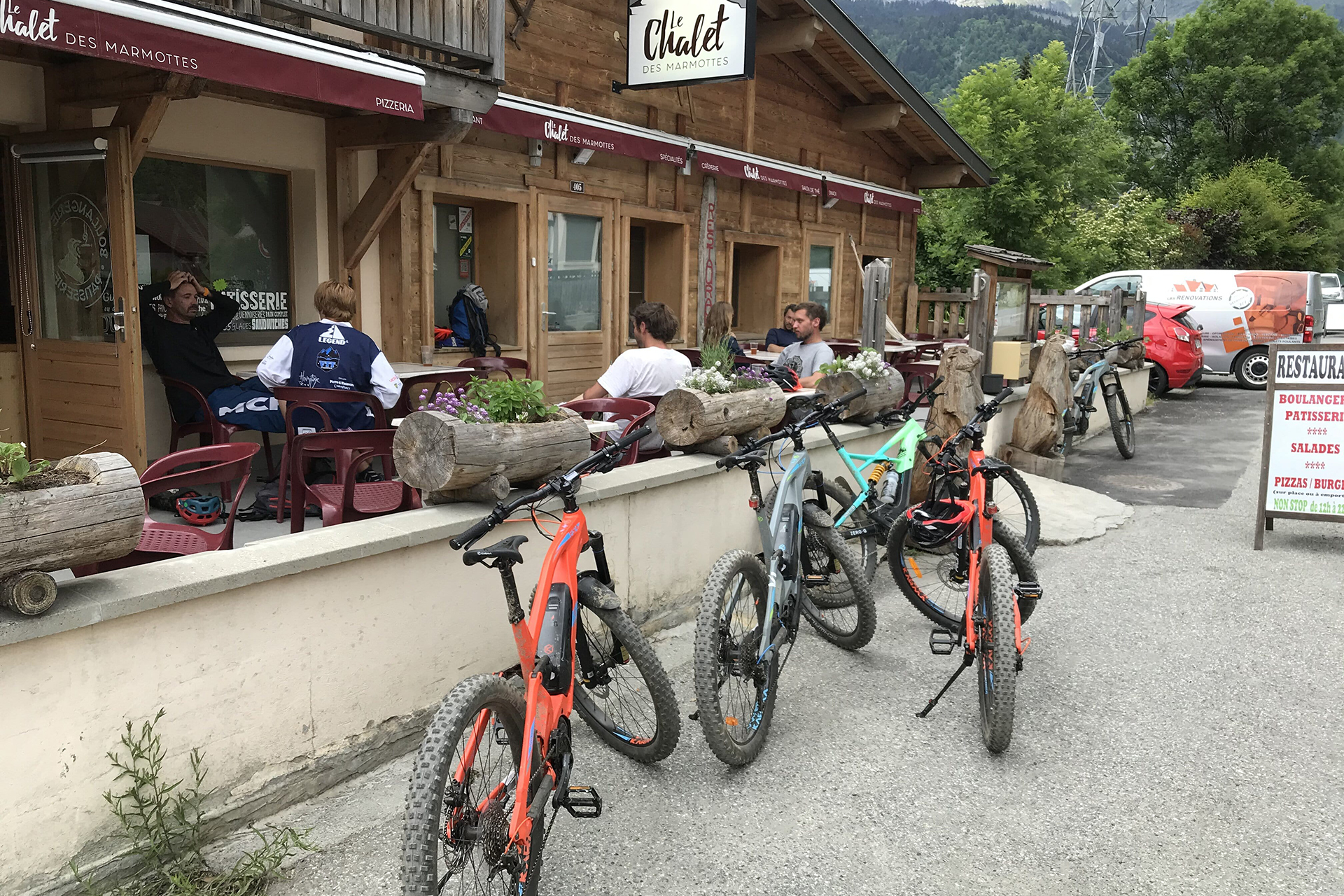 Un groupe de touristes en vélo électrique se repose dans un restaurant local dans les Alpes - rent-ebike-online.com